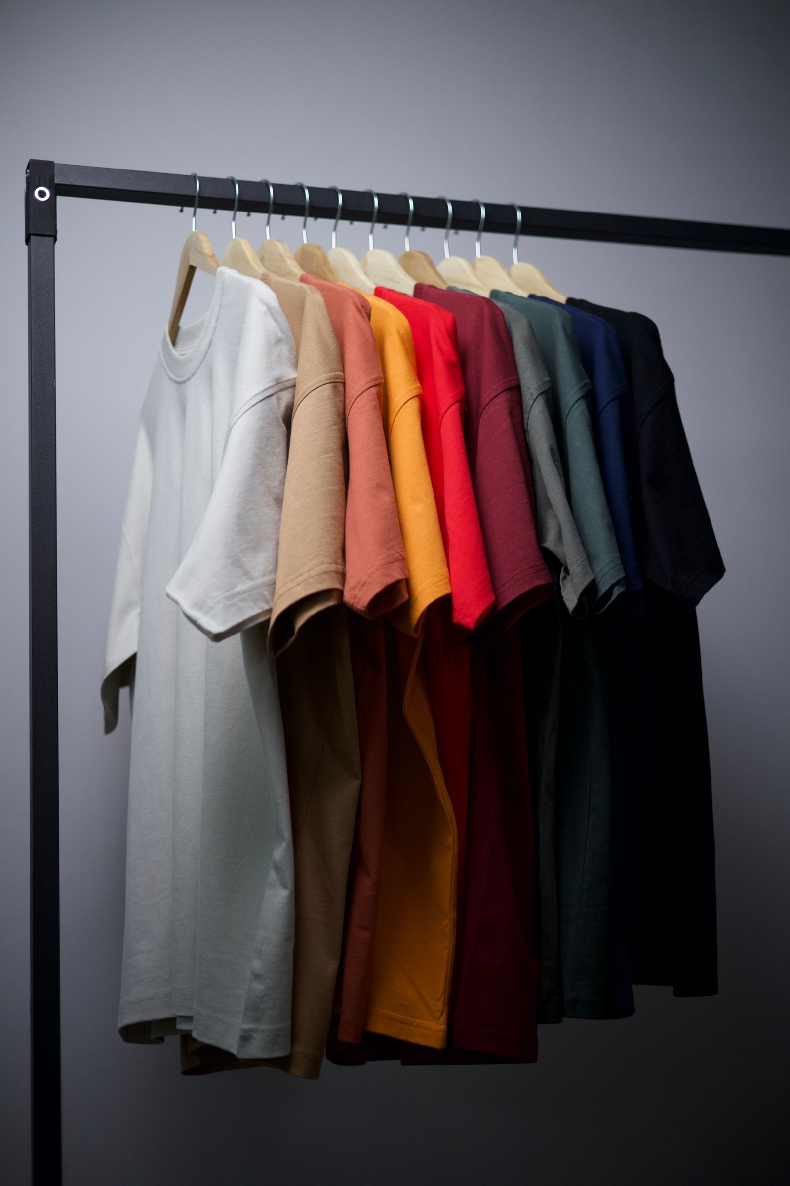 Plain T-shirts in a range of colours on a clothing rail